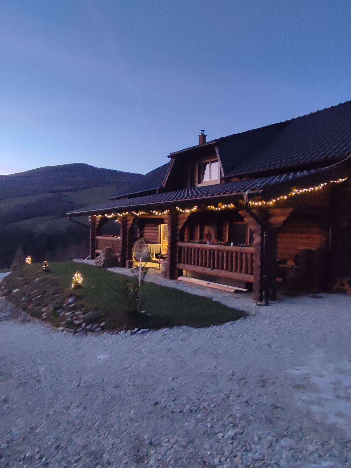 Maison en rondins au crépuscule avec éclairage et vue