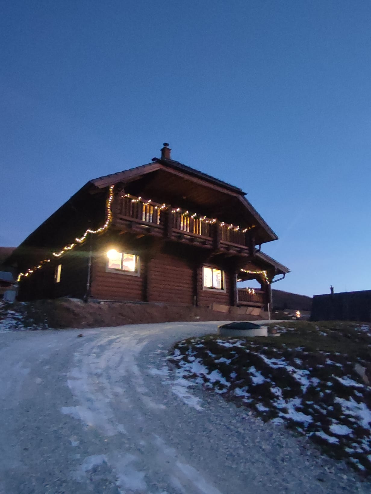 Maison en rondins en hiver avec illuminations de Noël