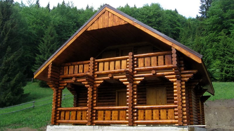 Maison en rondins à deux étages en milieu forestier